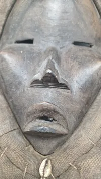 afrikansk maske fra Dan-folket i Liberia eller Elfenbenskysten, som er kendetegnet ved deres ofte ovale form, mørke træ og dekorationer som f.eks. kauriskaller