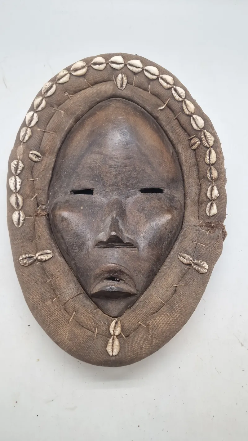 afrikansk maske fra Dan-folket i Liberia eller Elfenbenskysten, som er kendetegnet ved deres ofte ovale form, mørke træ og dekorationer som f.eks. kauriskaller