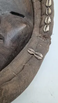 afrikansk maske fra Dan-folket i Liberia eller Elfenbenskysten, som er kendetegnet ved deres ofte ovale form, mørke træ og dekorationer som f.eks. kauriskaller