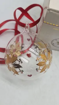 Holmegaard Christmas årets julekugle 2024, designet i klart glas med guld- og røde detaljer