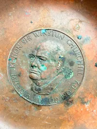 kobberskål med en mindemedalje af Sir Winston Churchill indlagt i midten.