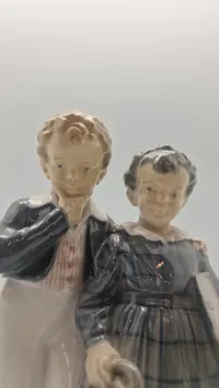 Royal Copenhagen figur kaldet "Flugten til Amerika" (model 1761), designet af Christian Thomsen i 1915