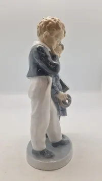 Royal Copenhagen figur kaldet "Flugten til Amerika" (model 1761), designet af Christian Thomsen i 1915