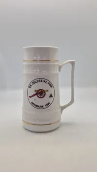 Søholm-keramikkrus med guldkant og et motiv af en kanon fra 1996