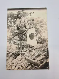 Billede af japansk soldat med gevær og flag, postwar