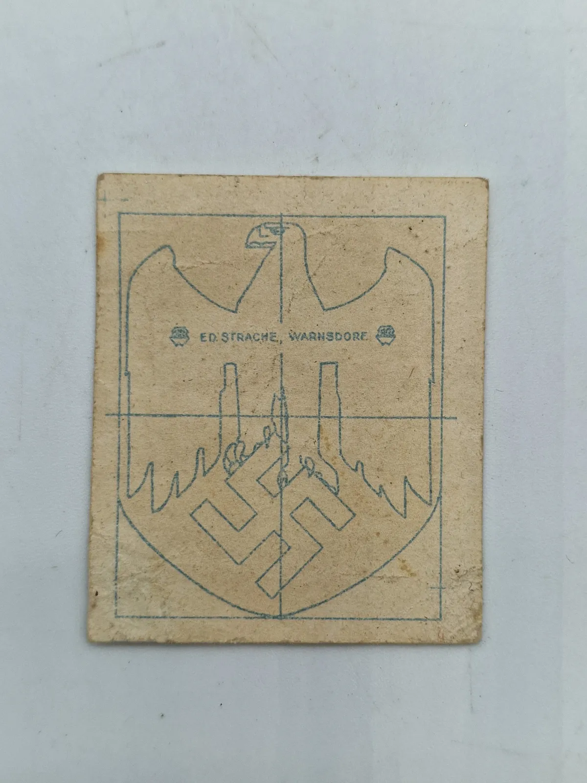 Papir ed strache hvorpå der har siddet original tysk hjelm decal