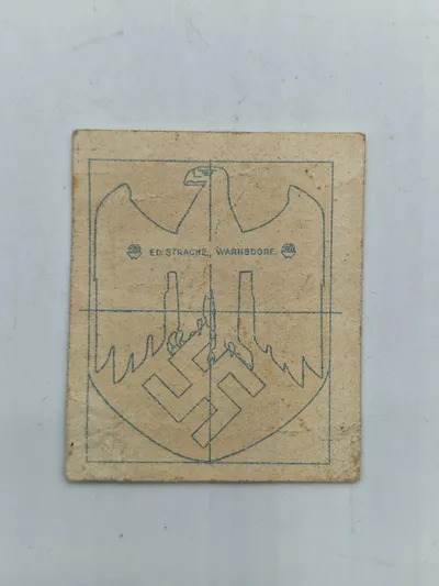 Papir ed strache hvorpå der har siddet original tysk hjelm decal
