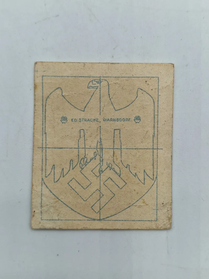 Papir ed strache hvorpå der har siddet original tysk hjelm decal
