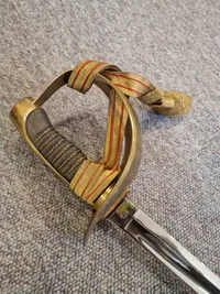 Fin velholdt dansk sabel M/1950 med fæste af forgyldt tombak.
Skede er forkromet stål