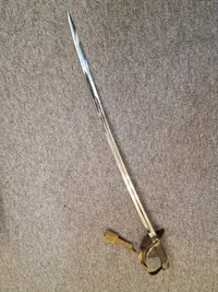 Fin velholdt dansk sabel M/1950 med fæste af forsølvet  tombak.
Skede er forkromet stål