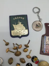 Samling af franske militære insignier, pins og nøgleringe