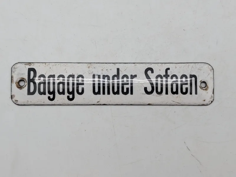 Antikt emaljeskilt med teksten Bagage under Sofaen DSB 