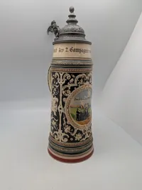 Tysk Regiments-ølkrus i stentøj med tinlåg og artillerimotiv