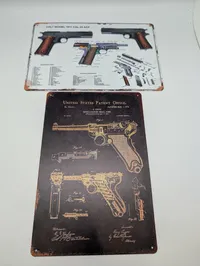 To metalskilte med Colt 1911 og Luger patenttegninger