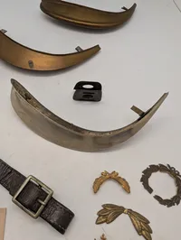 Samling af militære effekter, herunder hjelmdele, læderrem og emblemer