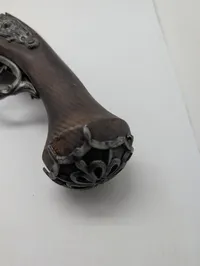 Dekorativ flintlåspistol i træ og metal med ornamenterede detaljer