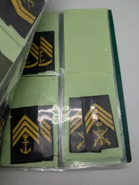 Samling af militære gradstegn og epauletter i mappe