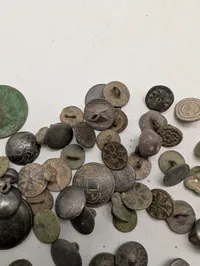 Samling af antikke og historiske metalknapper med dekorative motiver