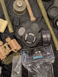 Militært udstyr med feltspader, gasmasker og hjelm