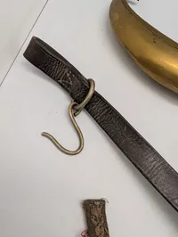 Samling af militære effekter, herunder hjelmdele, læderrem og emblemer