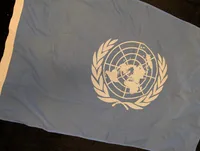 FN-flag i lyseblåt tekstil med hvidt emblem