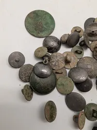 Samling af antikke og historiske metalknapper med dekorative motiver