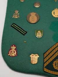 Samling af danske militære distinktioner og emblemer på grønt filt