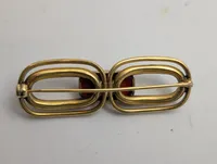 Vintage broche i forgyldt metal med rød cabochon