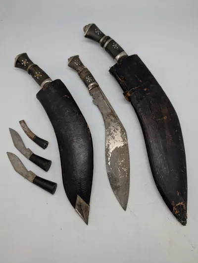 Tre nepalesiske Kukri-knive med læderskeder og småknive