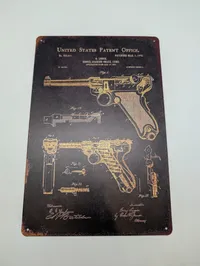 To metalskilte med Colt 1911 og Luger patenttegninger