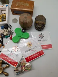 Samling af kuriositeter, herunder Knæk Cancer pins,  og spil