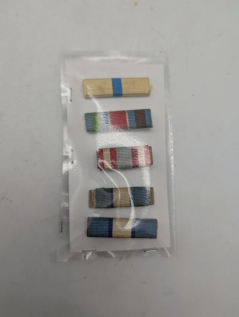 Samling af fem militære ordensbånd i plastlomme