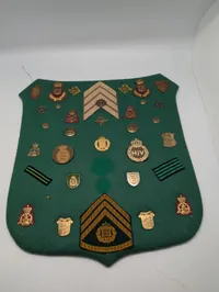 Samling af danske militære distinktioner og emblemer på grønt filt