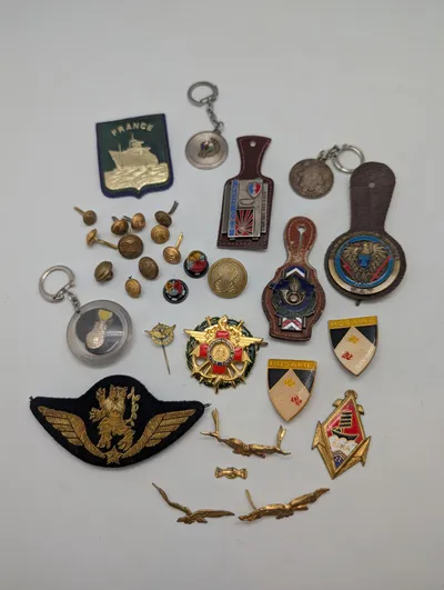 Samling af franske militære insignier, pins og nøgleringe