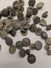 Samling af antikke og historiske metalknapper med dekorative motiver