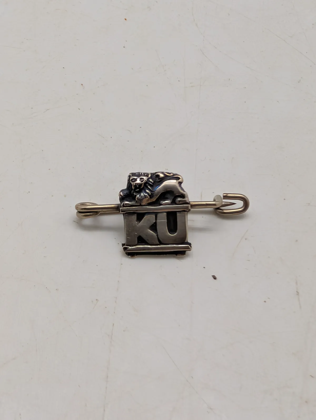 Antik broche i sølv med løvefigur og bogstaverne KU Konservativ Ungdom 