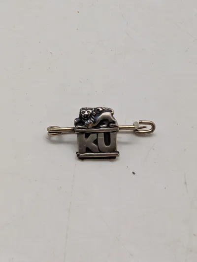 Antik broche i sølv med løvefigur og bogstaverne KU Konservativ Ungdom