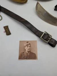 Samling af militære effekter, herunder hjelmdele, læderrem og emblemer