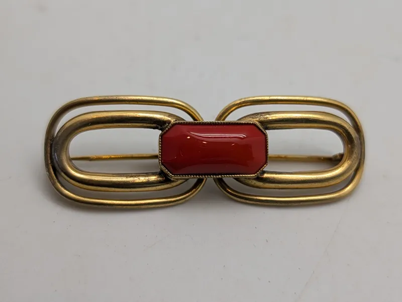 Vintage broche i forgyldt metal med rød cabochon