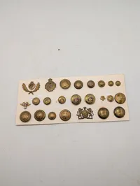 Samling af antikke og vintage militære knapper og emblemer