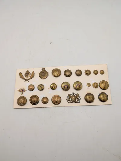 Samling af antikke og vintage militære knapper og emblemer