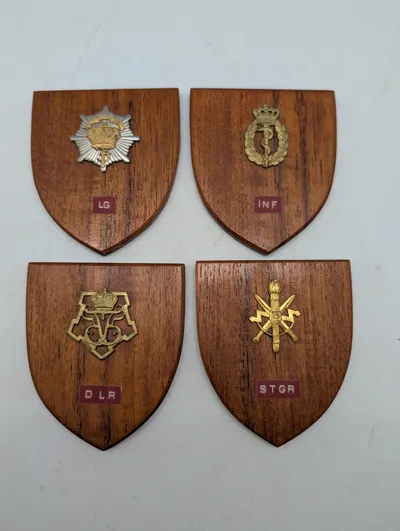 Fire danske militære træskjolde med emblemer: LG, INF, DLR og STGR