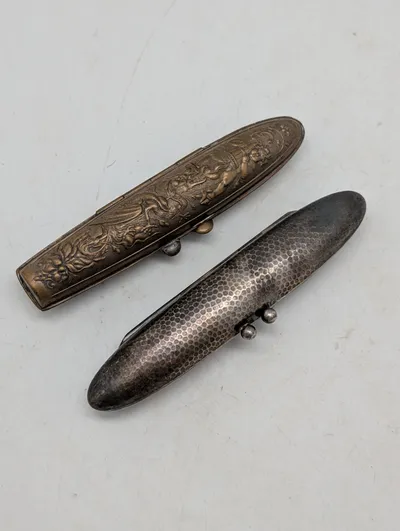 To antikke cigaretetuier i metal med relief og hamret finish