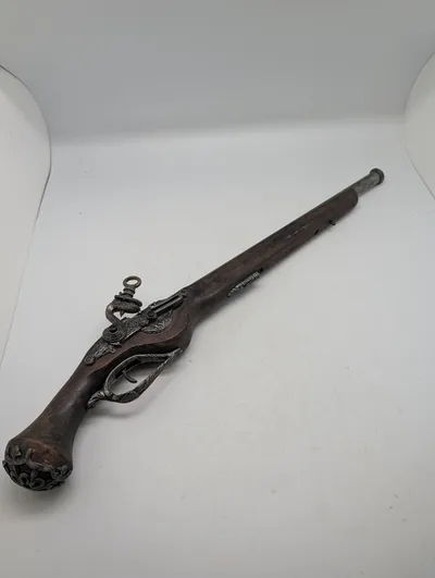 Dekorativ flintlåspistol i træ og metal med ornamenterede detaljer