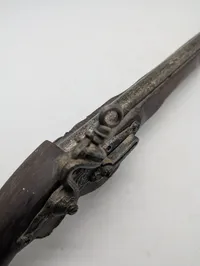 Dekorativ flintlåspistol i træ og metal med ornamenterede detaljer