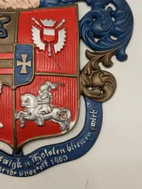 Støbejernsvåbenskjold med Slesvig-Holsten motiv og motto