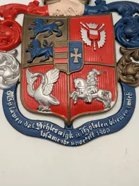 Støbejernsvåbenskjold med Slesvig-Holsten motiv og motto