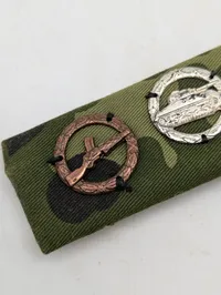 Militær bånd med fire færdighedstegn på camouflagebund