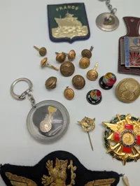 Samling af franske militære insignier, pins og nøgleringe