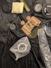 Militært udstyr med feltspader, gasmasker og hjelm